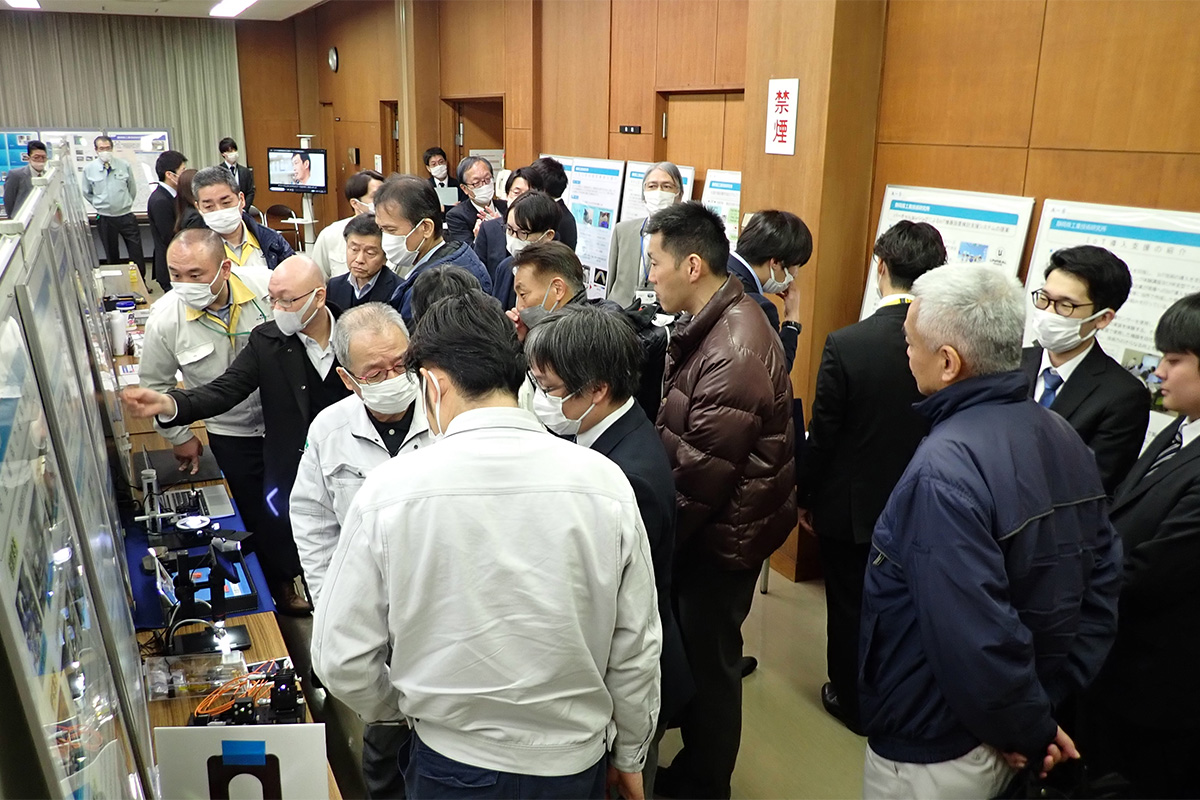 展示熱心に見る学生と関係者の様子